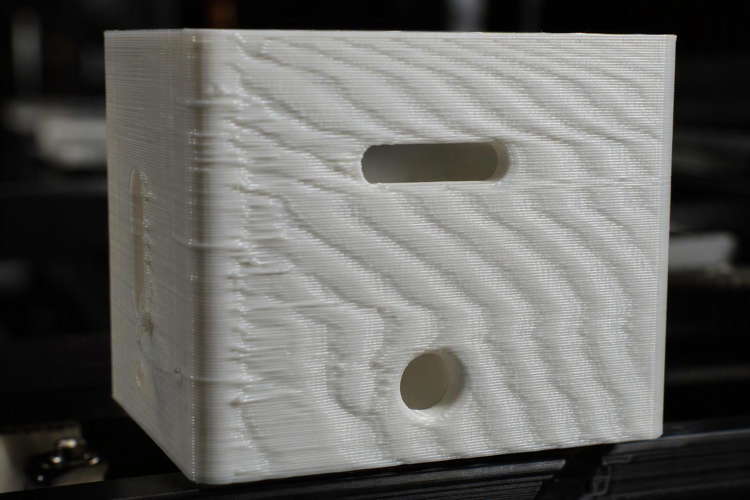 Close-up of repeating ripple and ghosting marks on a 3D printed surface caused by frame resonance