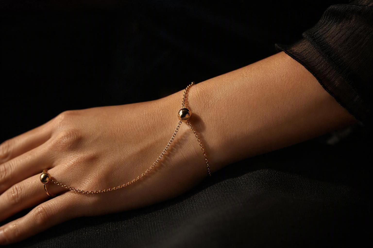 a woman's forearm and hand at rest on a dark surface, a fine-jewellery bracelet and a connected ring or hybrid watch worn together on the same arm, sh